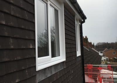 Outside view of loft conversion - white windows with tiled walling