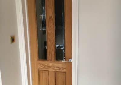 Wooden door with dual panelling in white frame